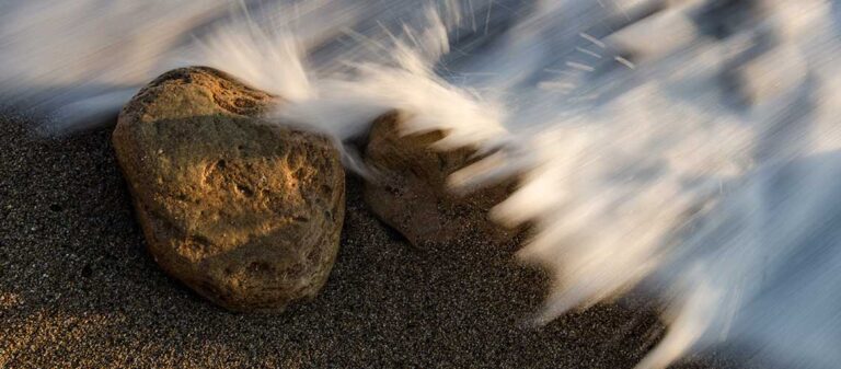 stenpå en strand som sköljs av vatten från havet
