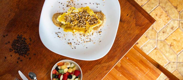 vita tallrikar med smörgås och fruktsallad