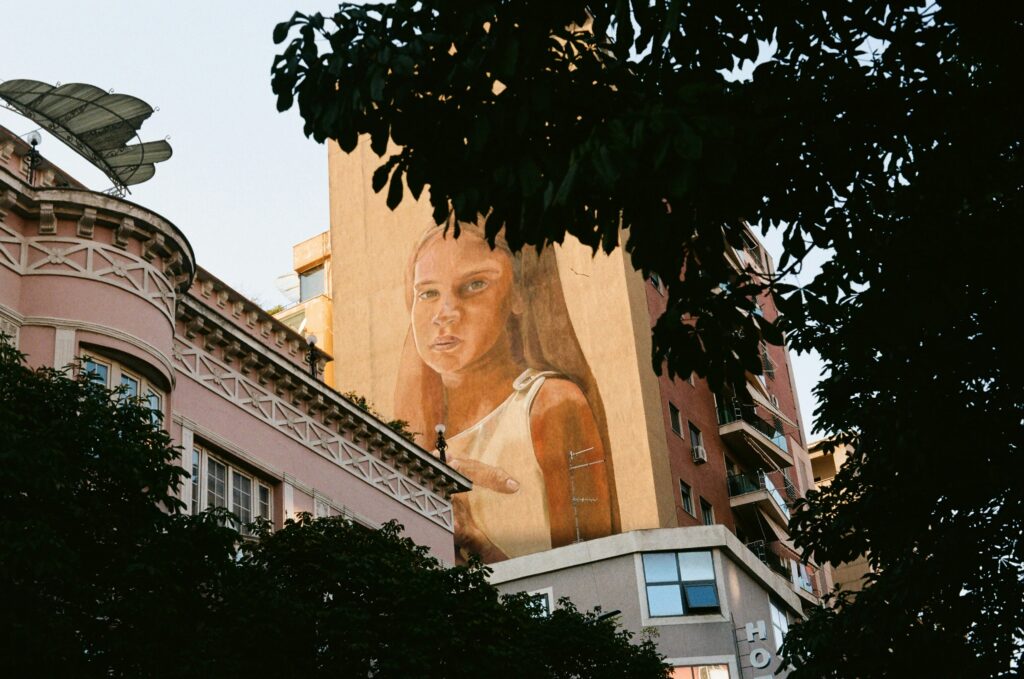 väggmålning av flicka på högt hus